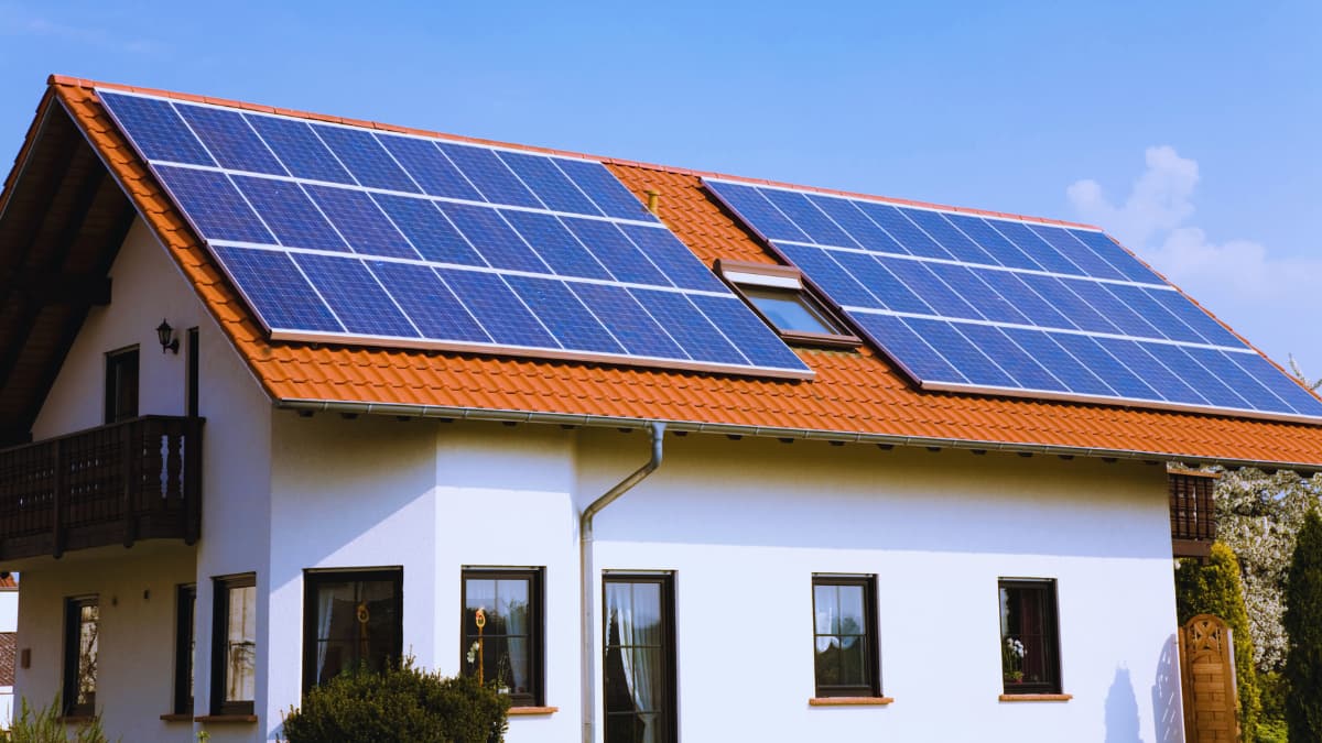 Blauwe zonnepanelen op het schuine dak van een vrijstaande woning